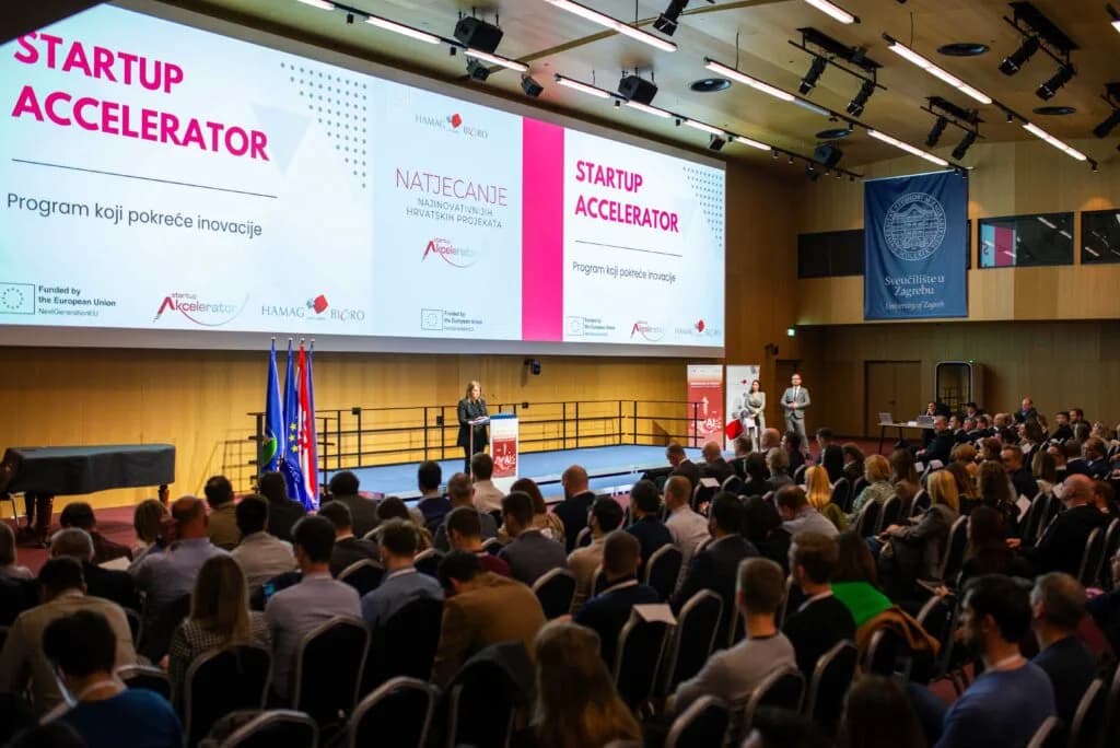 A big hall with a stage and a large screen showing 'Startup Accelerator'